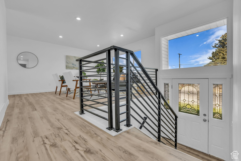 Foyer featuring wood finished floors, recessed lighting, and stairs