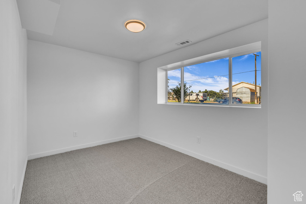 Carpeted empty room featuring baseboards