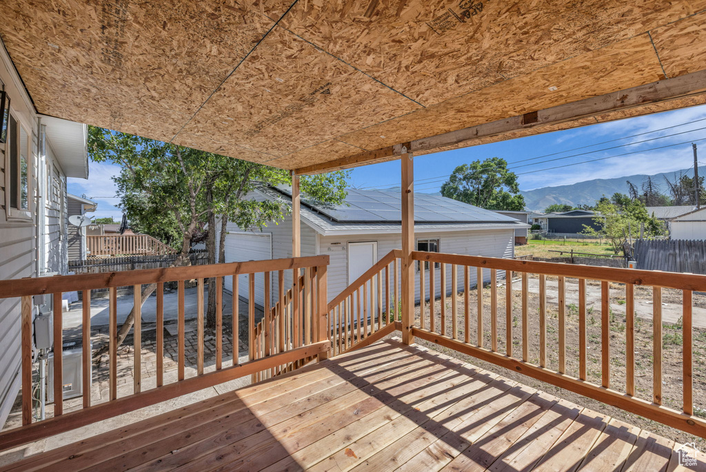 Wooden deck with an outdoor structure, a mountain view, and a garage