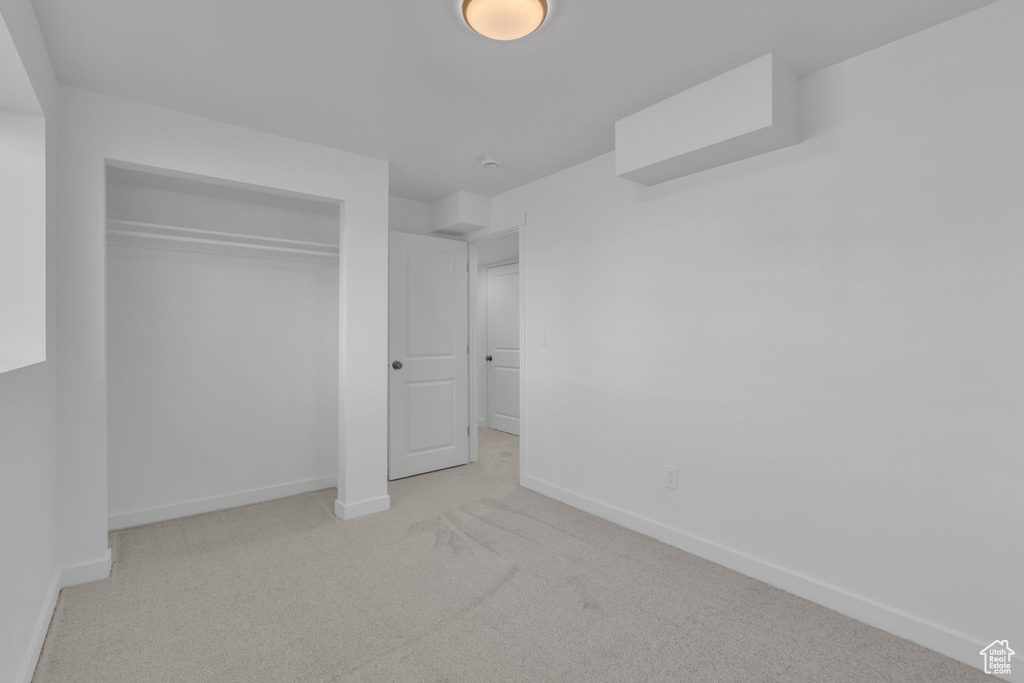 Unfurnished bedroom with carpet and a closet