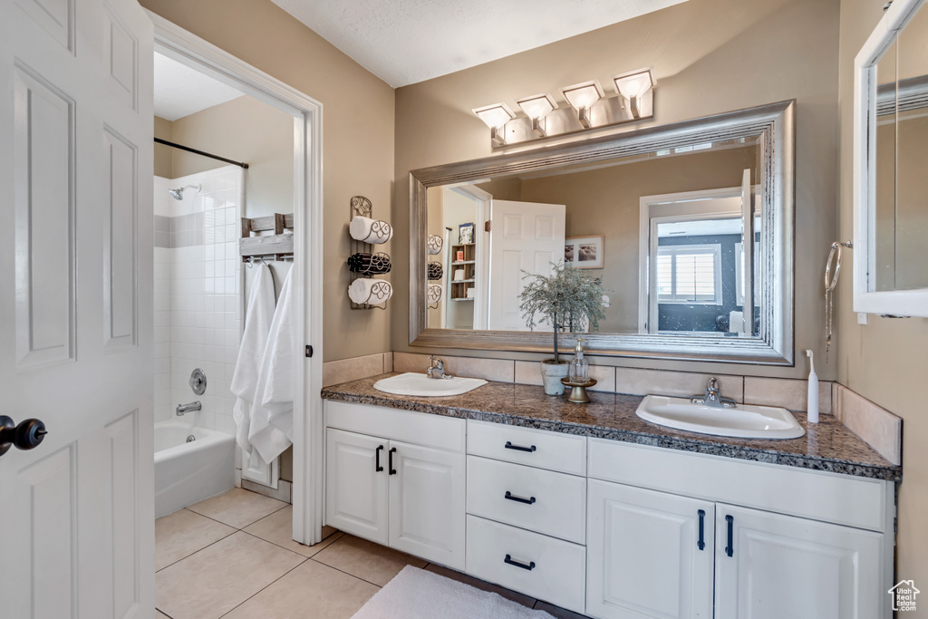 Full bath featuring double vanity, shower / bathtub combination with curtain, and tile patterned floors