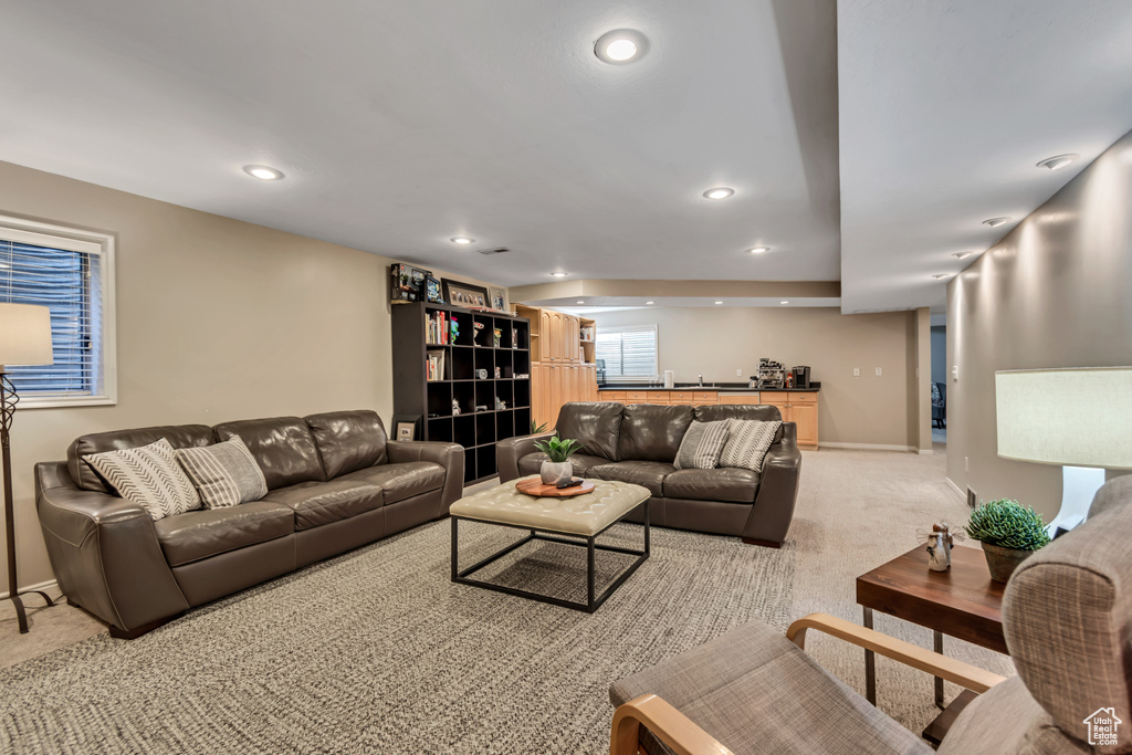 Living room with light colored carpet, bar area, and recessed lighting