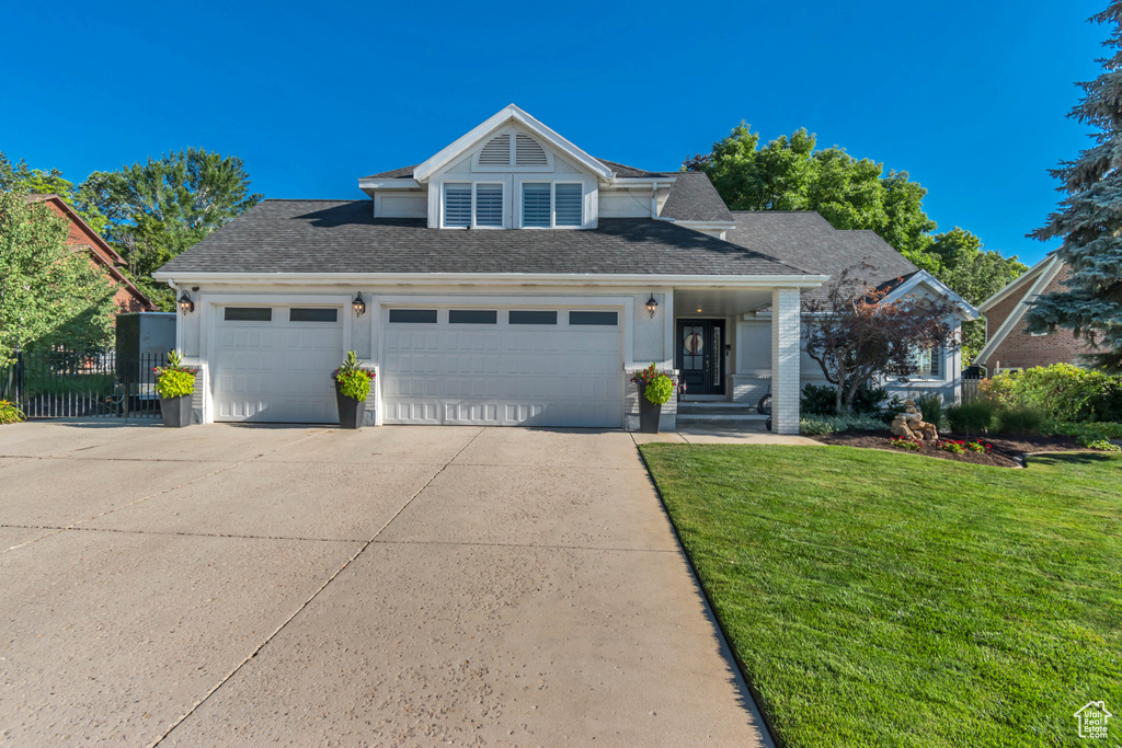 Traditional home featuring concrete driveway, an attached garage, and a shingled roof