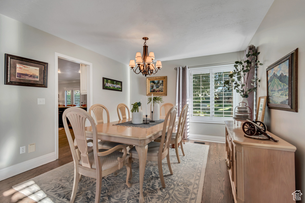 Dining room featuring wood finished floors and a chandelier