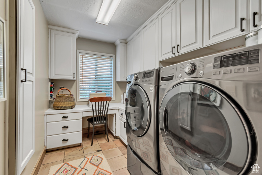 Washroom with washing machine and clothes dryer, cabinet space, a textured ceiling, a desk, and light tile patterned floors