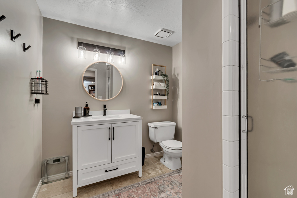 Full bath featuring vanity, a stall shower, and tile patterned floors