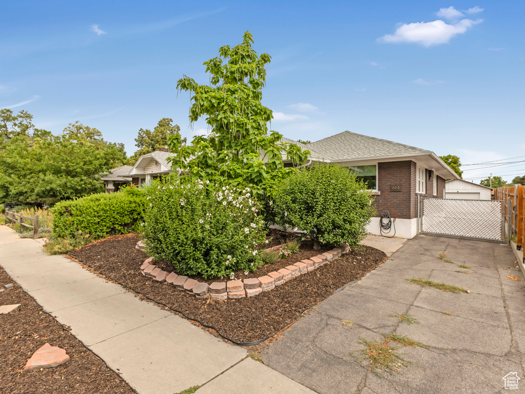 View of home's exterior with brick siding, driveway, and roof with shingles