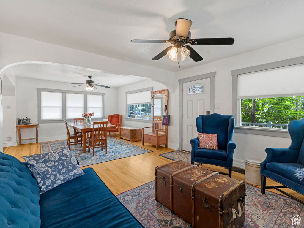 Living room with arched walkways, ceiling fan, and plenty of natural light