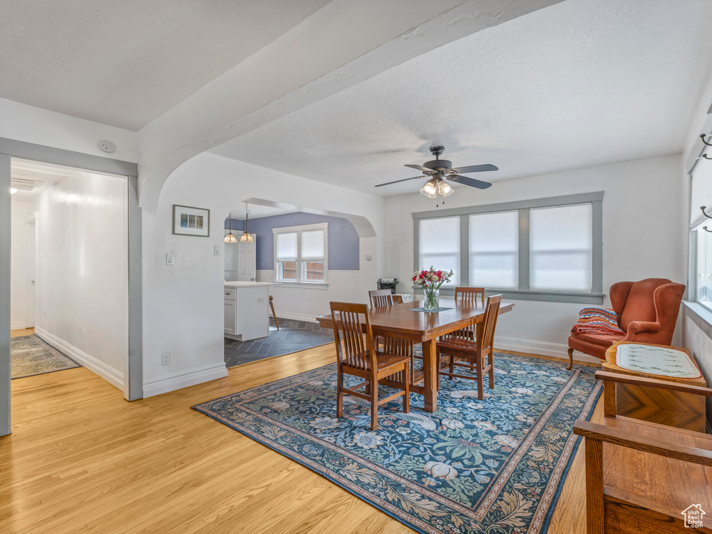 Dining area featuring arched walkways, ceiling fan, and wood finished floors