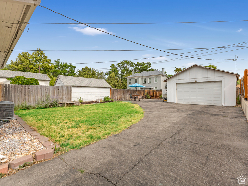 Fenced backyard with a detached garage and an outbuilding