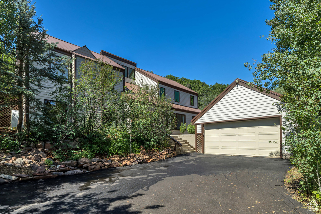 View of front of property featuring stairs and an outdoor structure