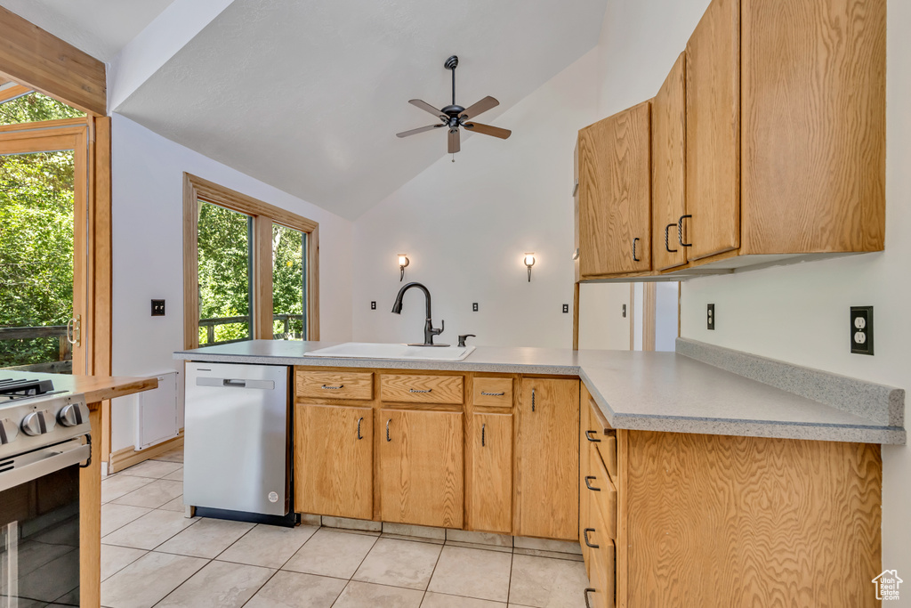Kitchen featuring stainless steel appliances, a peninsula, lofted ceiling, a ceiling fan, and light countertops