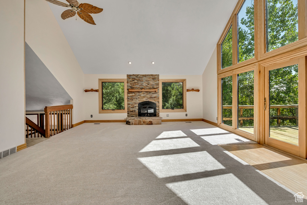 Unfurnished living room featuring high vaulted ceiling, carpet floors, and ceiling fan