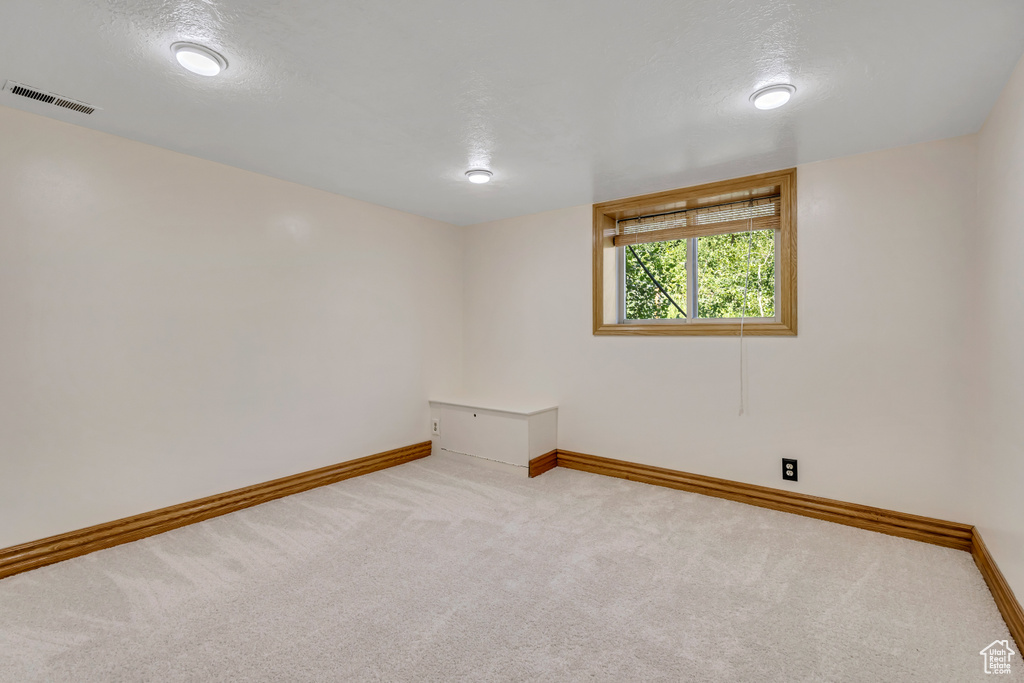 Carpeted spare room with baseboards and a textured ceiling
