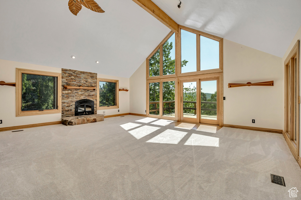 Unfurnished living room featuring high vaulted ceiling and light carpet