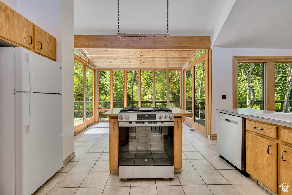 Kitchen featuring appliances with stainless steel finishes, light countertops, light tile patterned floors, vaulted ceiling, and wooden ceiling