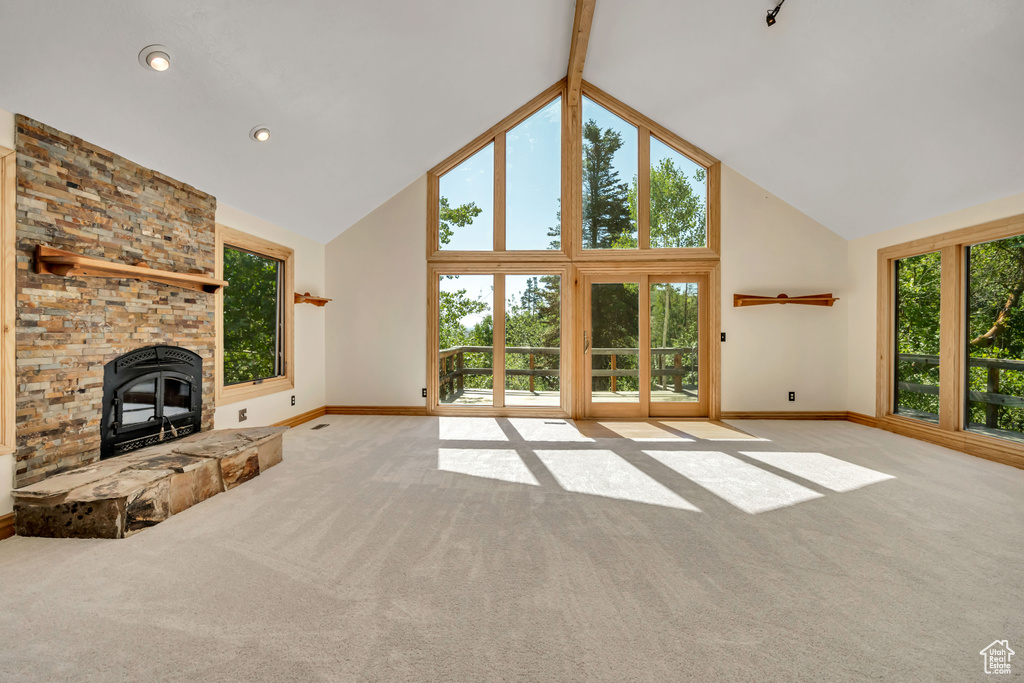 Unfurnished living room with plenty of natural light, carpet floors, and high vaulted ceiling