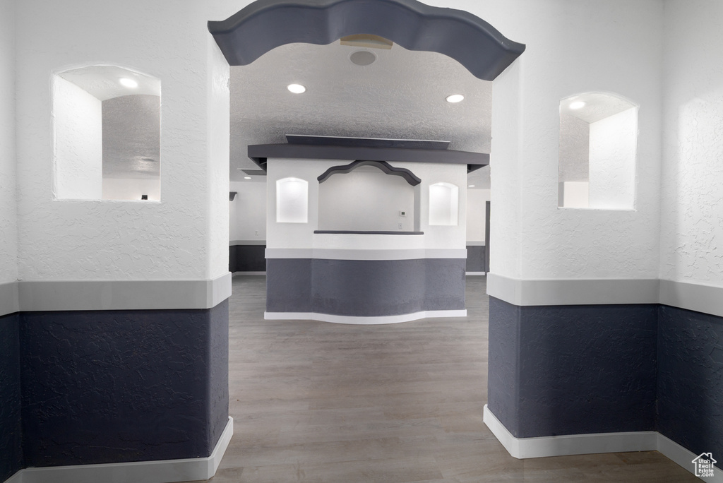 Hall with a textured wall and wood finished floors