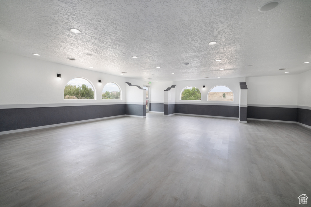 Unfurnished living room featuring a textured ceiling, wood finished floors, and recessed lighting