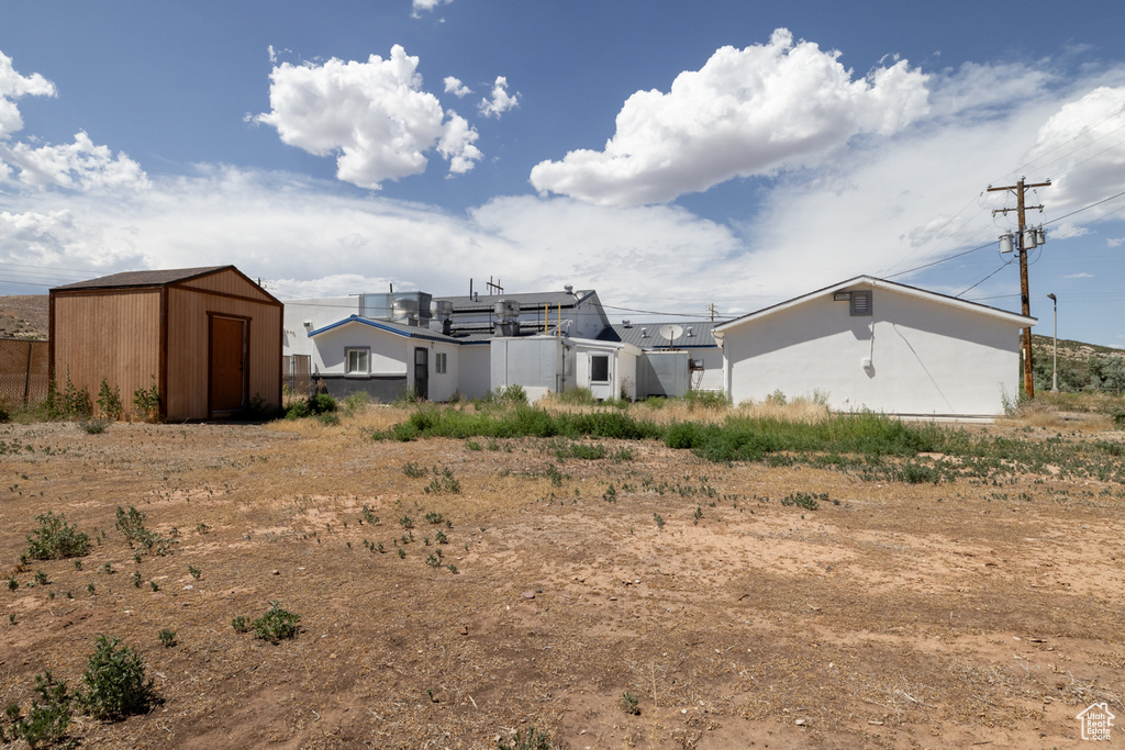 Rear view of property featuring a storage shed