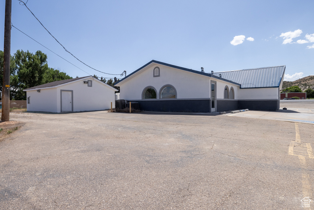 View of side of home featuring a metal roof and stucco siding
