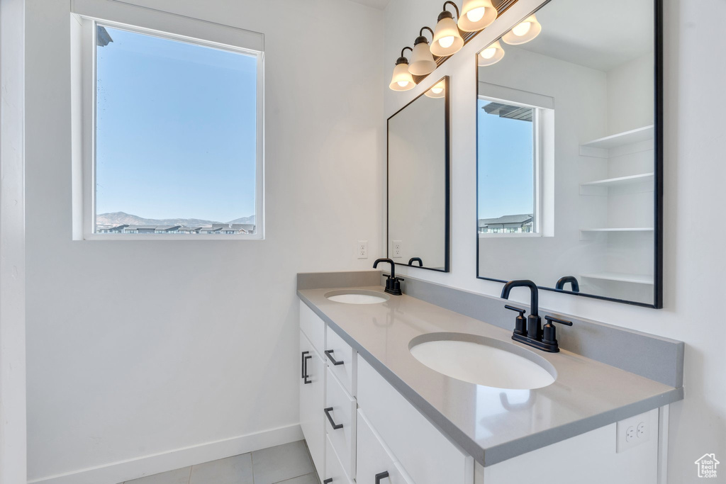 Bathroom with double vanity and tile patterned floors