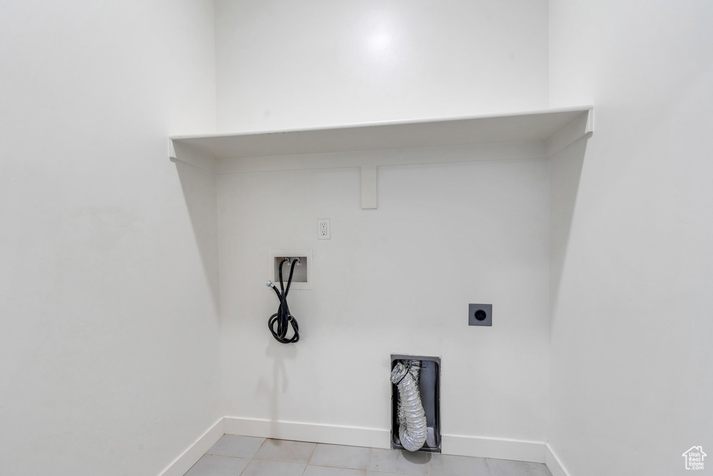 Laundry area featuring hookup for an electric dryer, washer hookup, and light tile patterned flooring