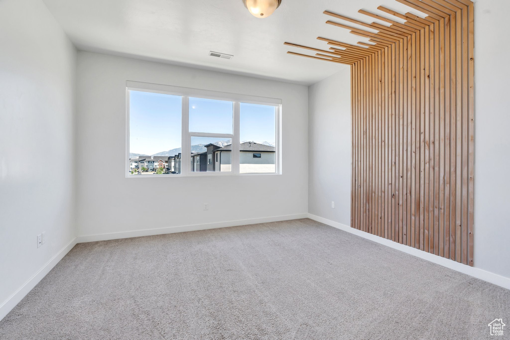 Empty room featuring carpet and baseboards