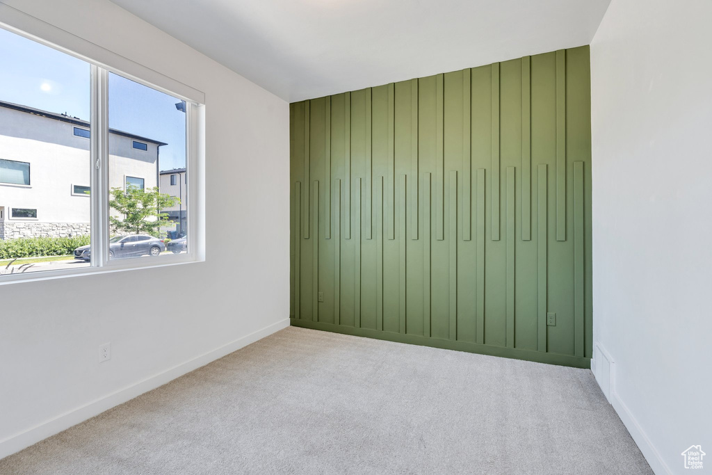 Carpeted spare room featuring baseboards