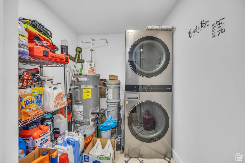 Laundry room featuring stacked washer and clothes dryer and water heater