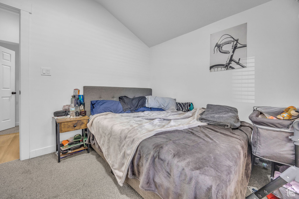 Carpeted bedroom featuring vaulted ceiling