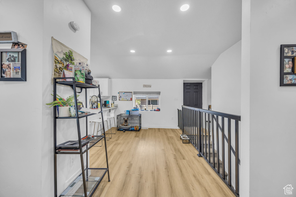 Hall with light wood-style flooring, recessed lighting, and an upstairs landing