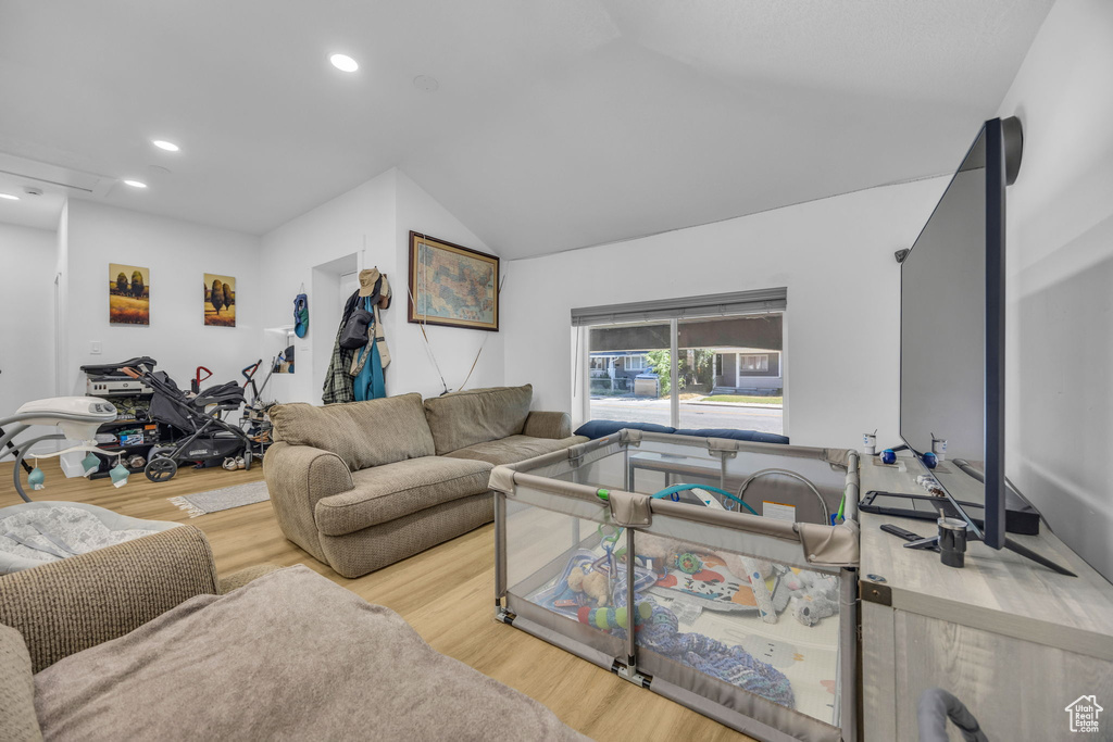 Living area with wood finished floors, recessed lighting, and vaulted ceiling