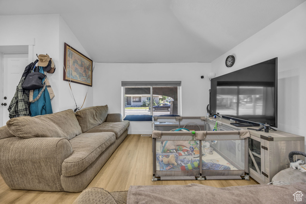 Living room featuring wood finished floors and vaulted ceiling