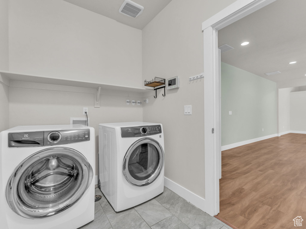 Washroom with washing machine and clothes dryer and recessed lighting
