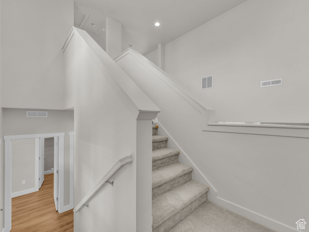 Stairway with recessed lighting and wood finished floors