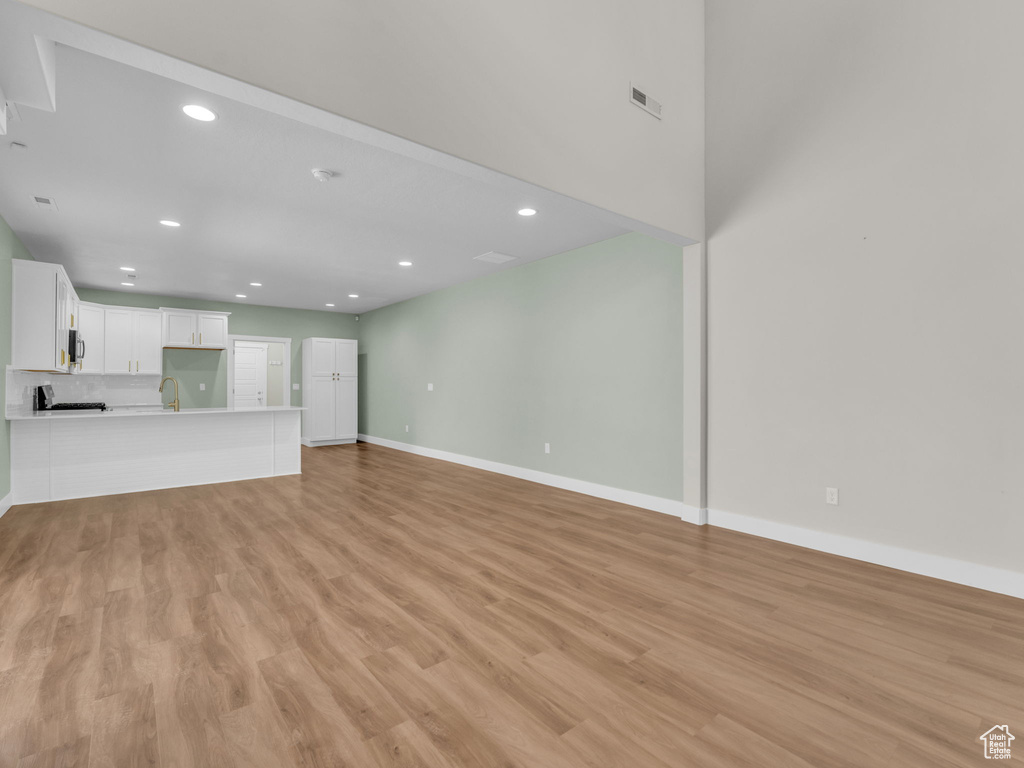 Unfurnished living room featuring light wood-style flooring and recessed lighting