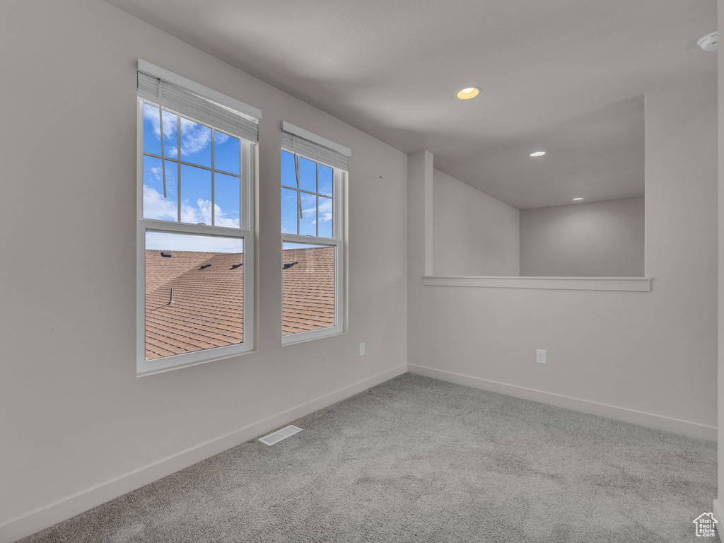 Carpeted empty room featuring baseboards and recessed lighting