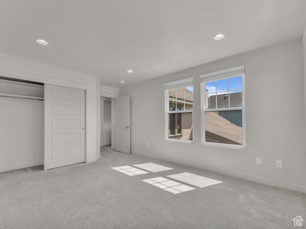 Unfurnished bedroom featuring carpet flooring, recessed lighting, and a closet