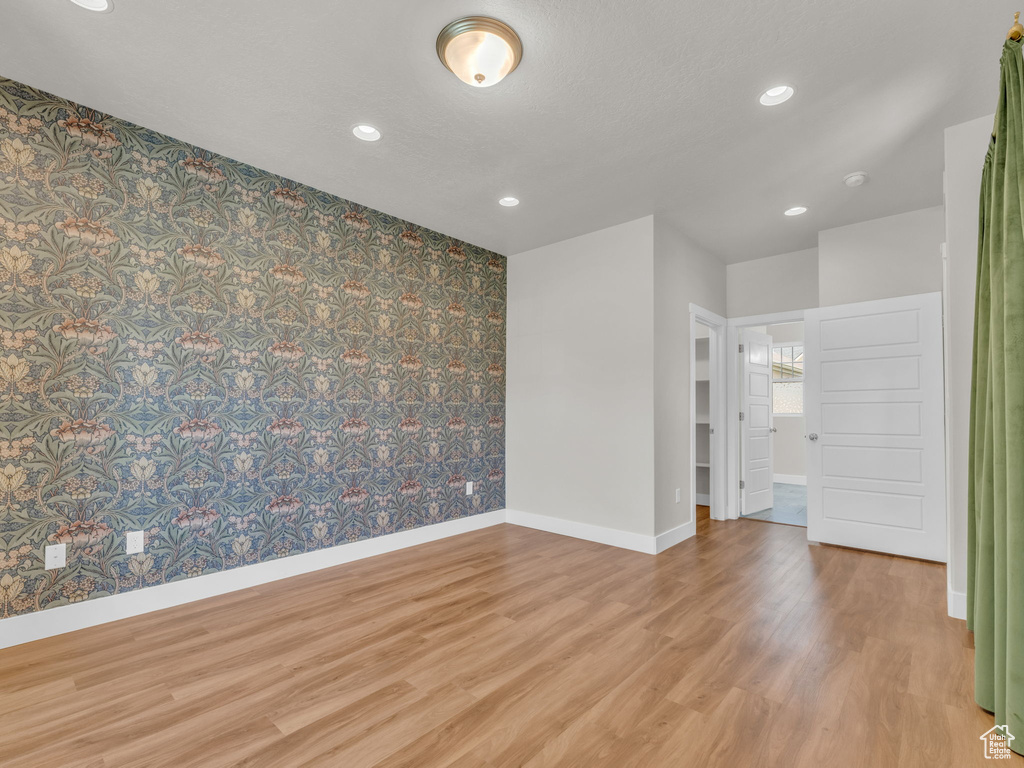 Unfurnished room featuring wood finished floors, recessed lighting, and wallpapered walls
