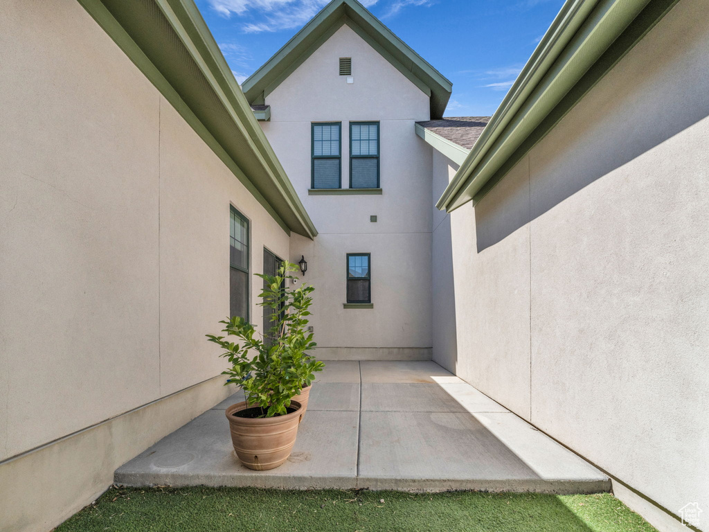 View of side of home featuring stucco siding and a patio area
