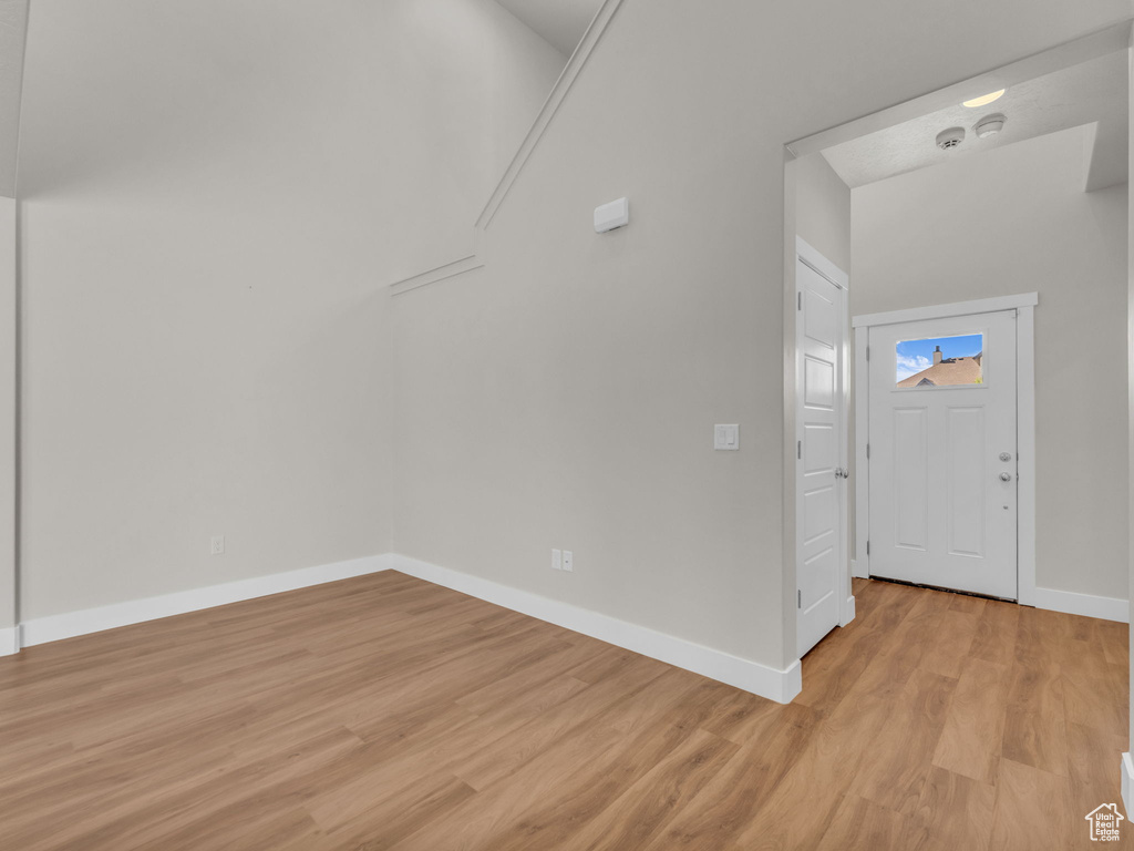 Foyer entrance with light wood-style flooring and baseboards