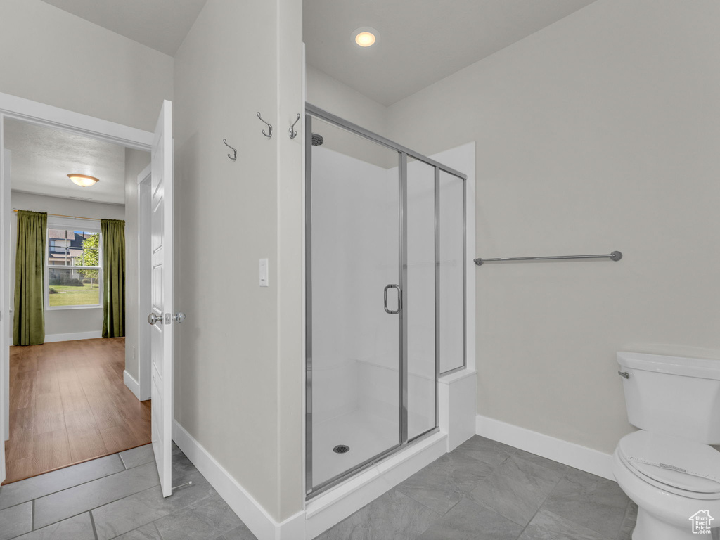 Bathroom with a shower stall and marble look tiles