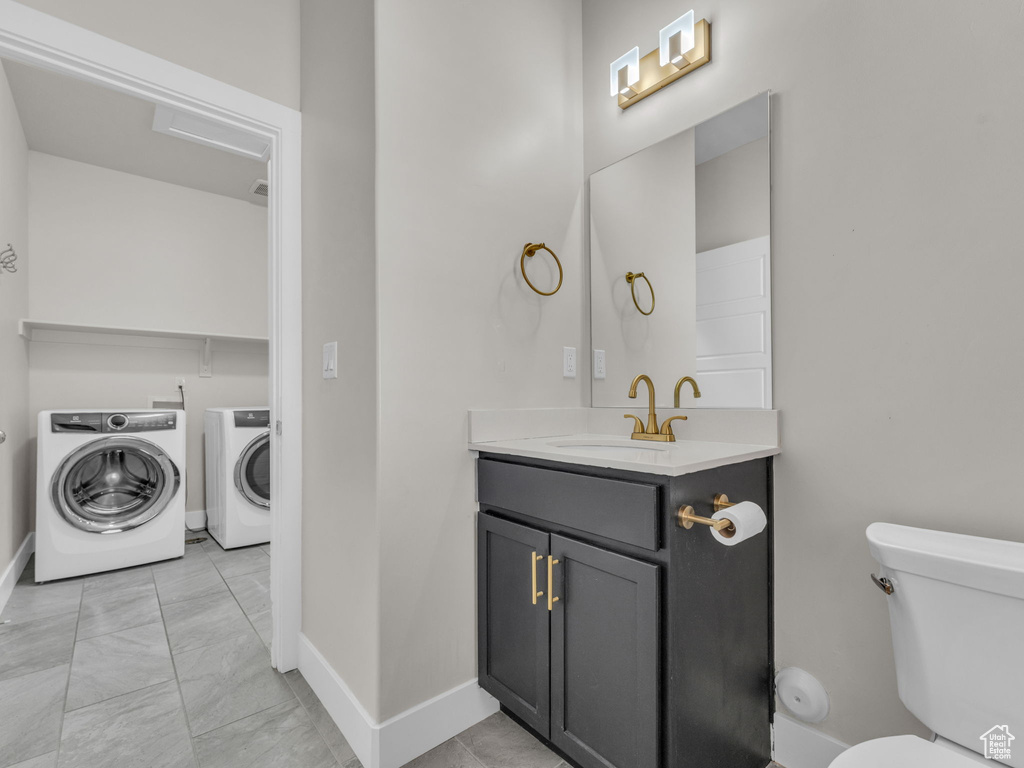 Bathroom with vanity, independent washer and dryer, and marble look tile flooring