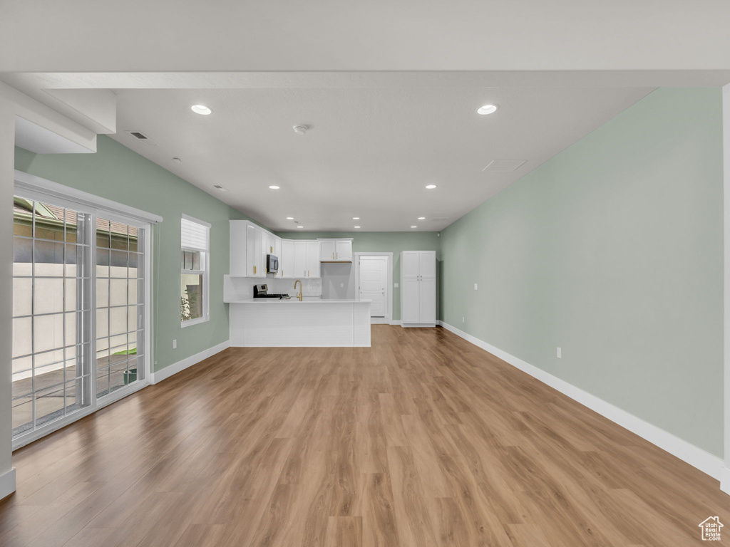 Unfurnished living room featuring light wood finished floors and recessed lighting