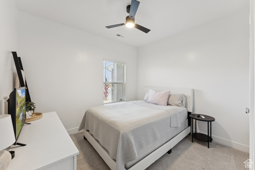 Bedroom with light colored carpet and ceiling fan