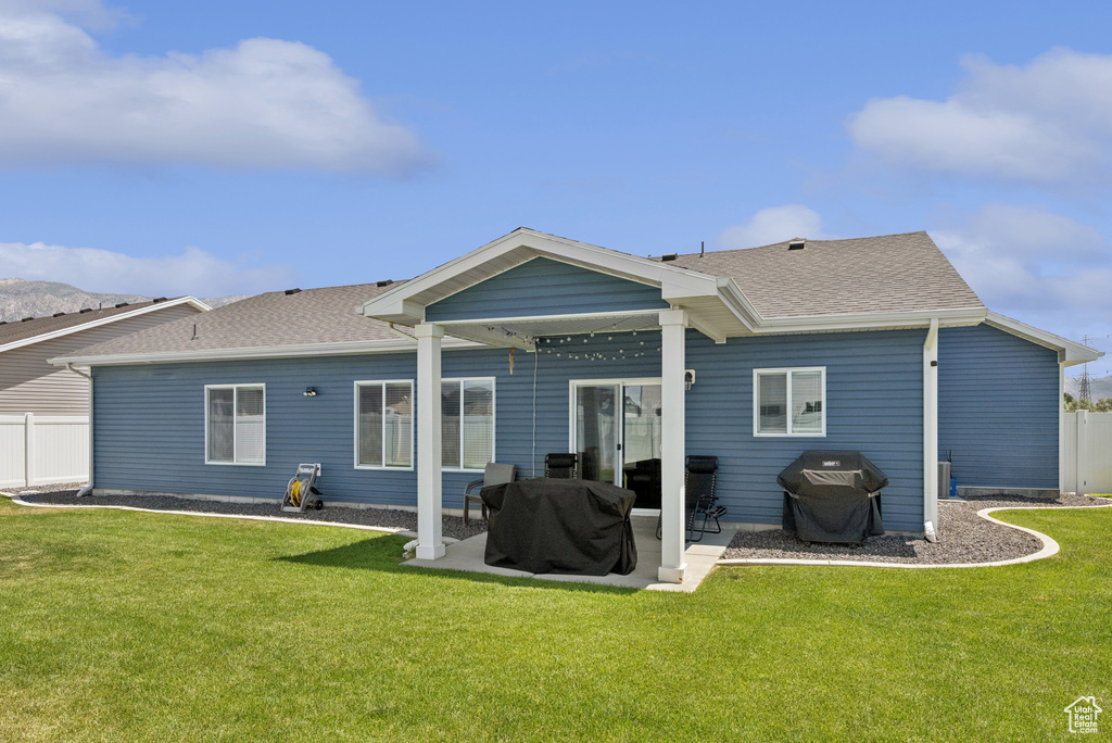Rear view of property featuring a patio and a shingled roof