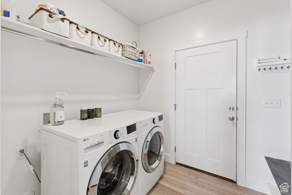 Laundry area featuring washer and clothes dryer and light wood finished floors