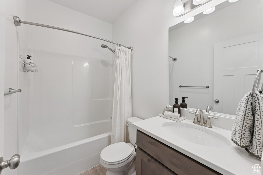 Bathroom featuring shower / bath combo, vanity, and wood finished floors