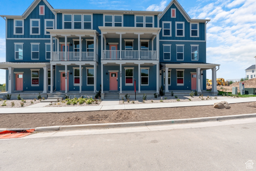 View of front of home featuring a balcony and covered porch